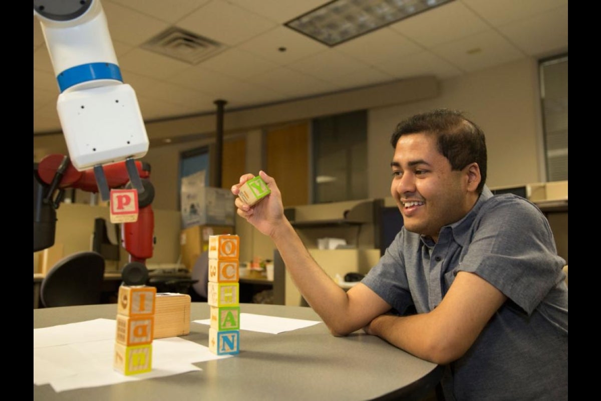 Tathagata Chakraborti and industrial robot Kramer stack building blocks to fork the words 