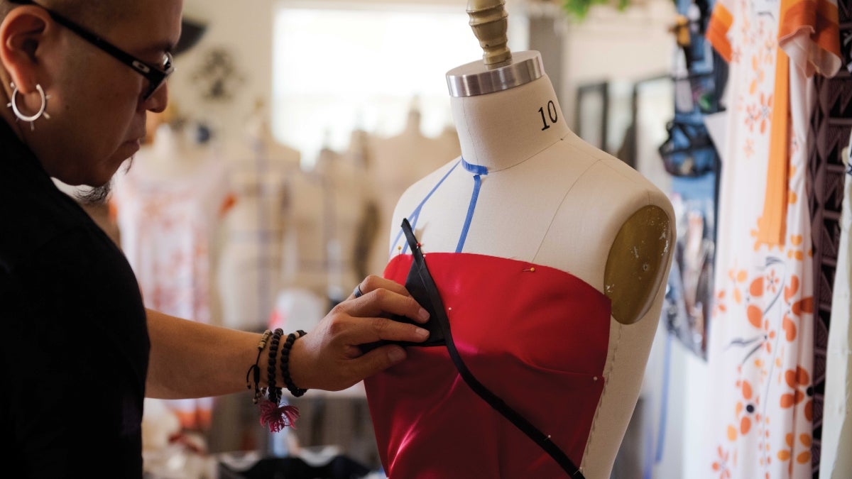 Designer Loren Aragon works on a dress on a dressmaker mannequin