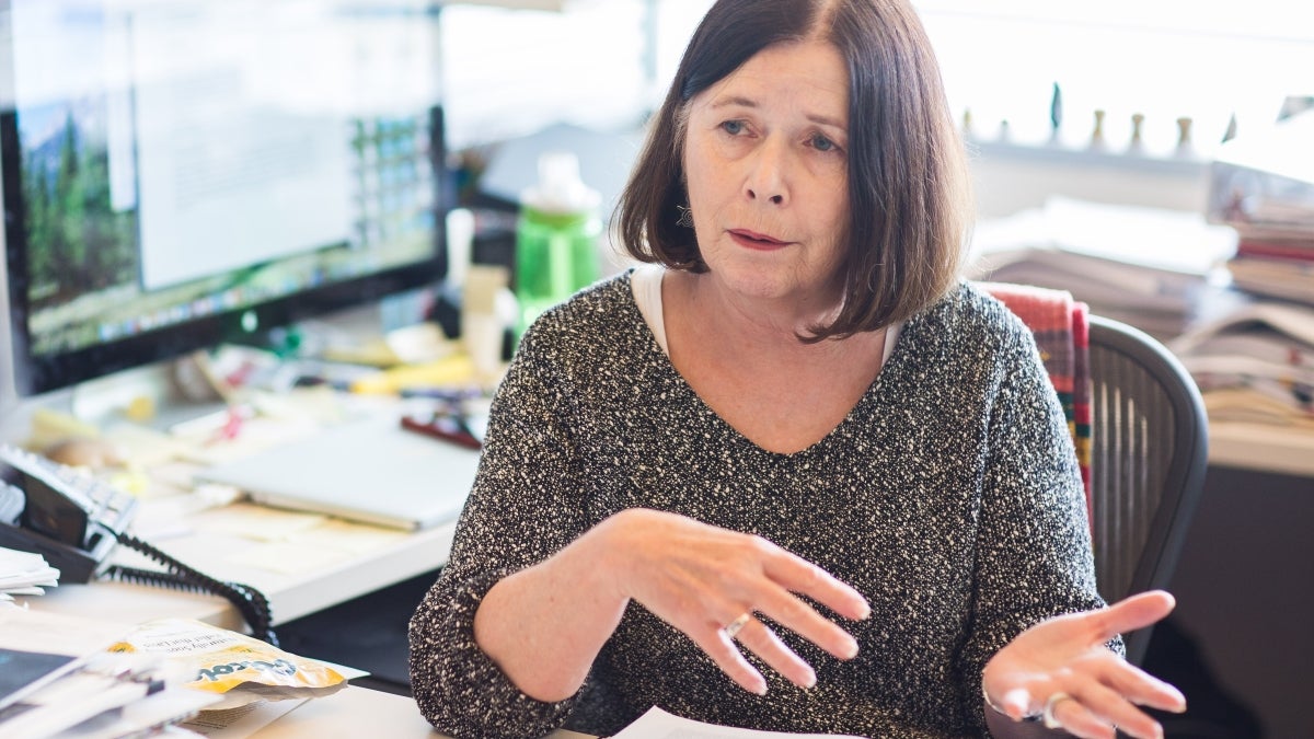 A professor sits at a desk in her office.