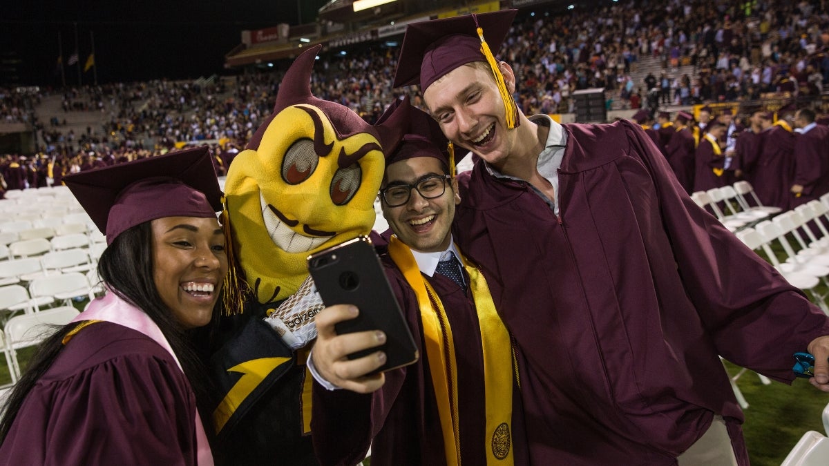 New ASU graduates pose with Sparky at commencement