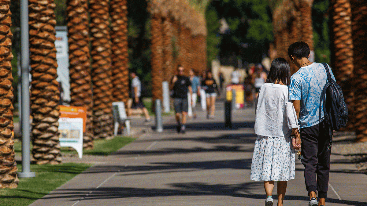 Couple holds hands on Palm Walk