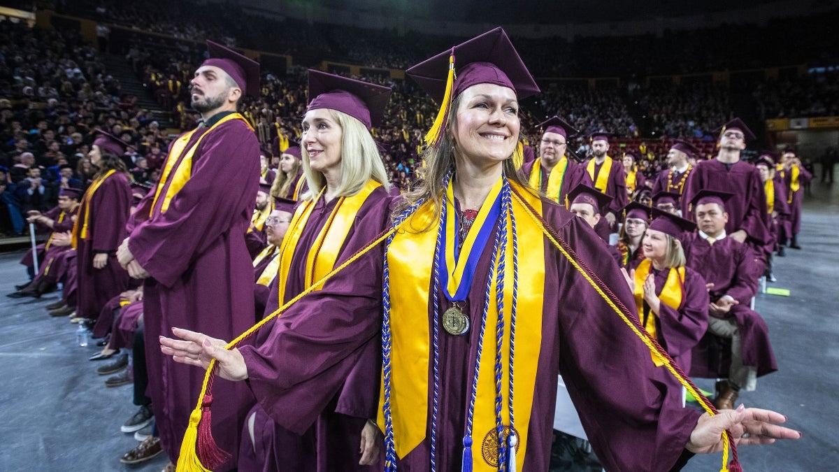 student holding cords out at graduation