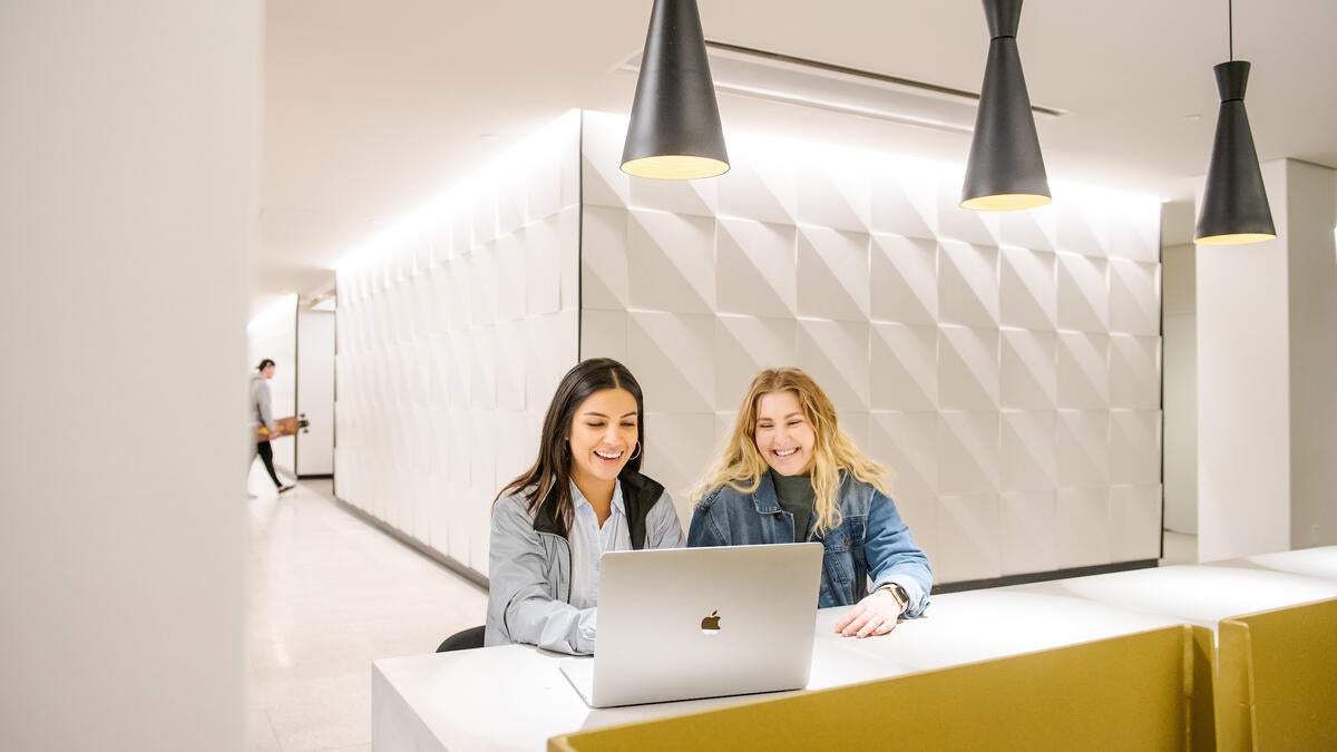 two people looking at laptop in library