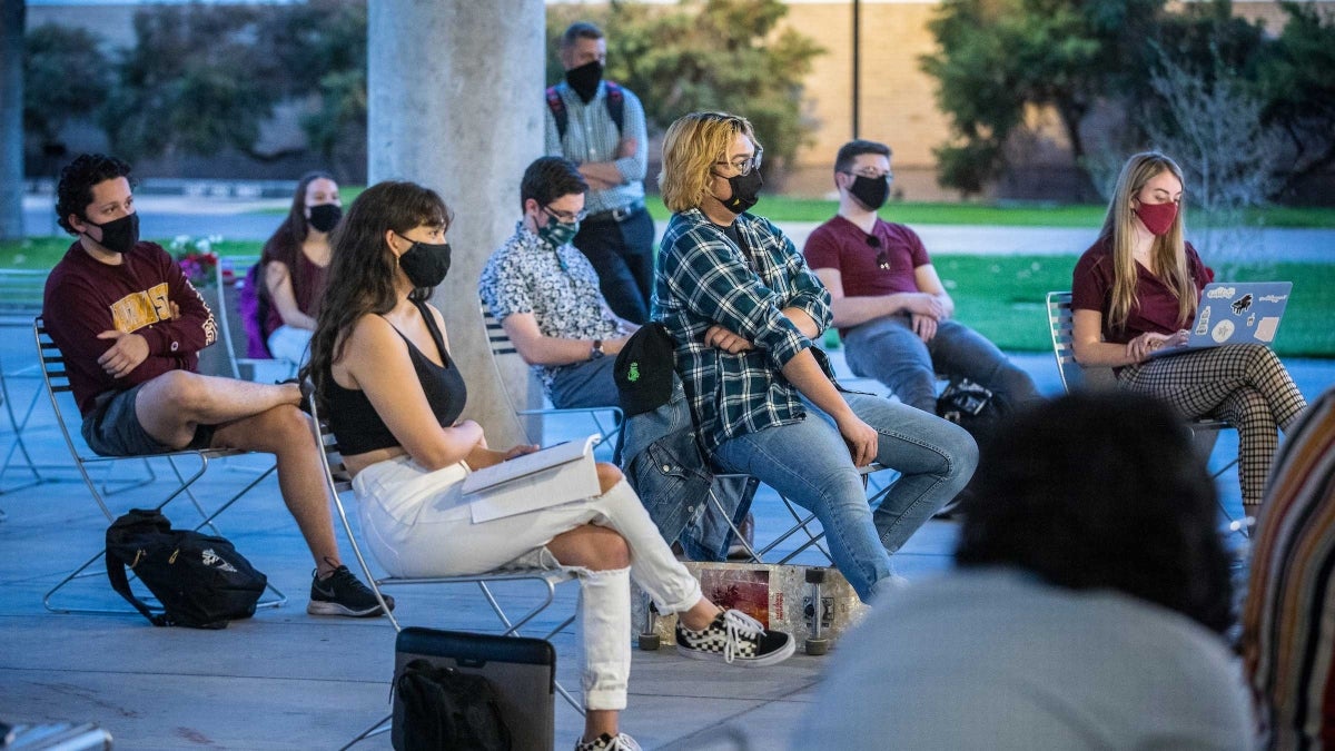 Students sit socially distanced outside to discuss the election