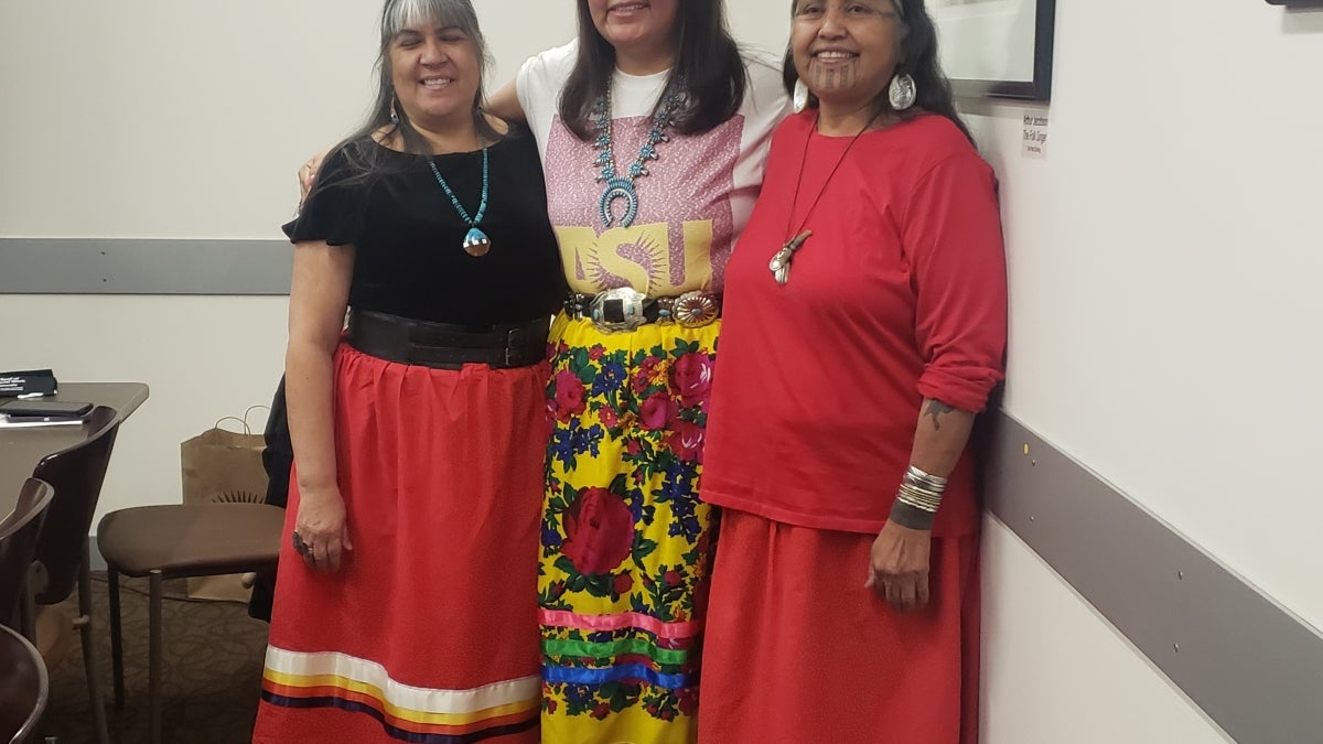 ASU alum Kelly Vallo wears a red ribbon skirt signifying her membership in the HONOR Collective, along with fellow matriarchs Melodie Lopez and Thomasa Riva.