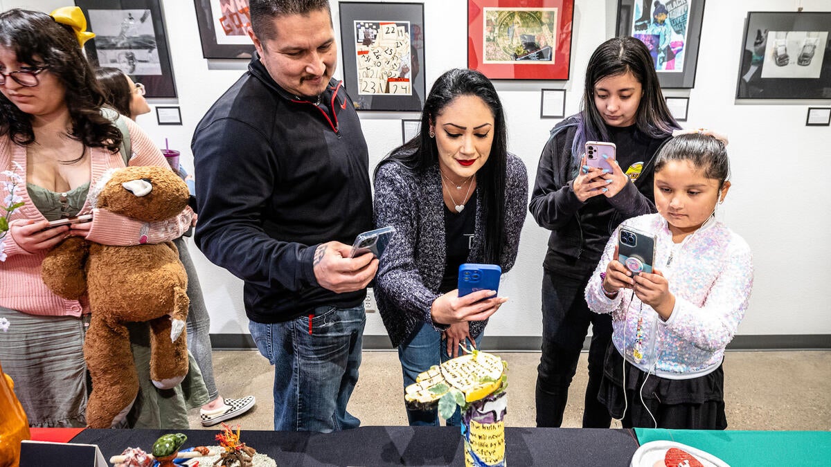 A family takes photos of art at an exhibit