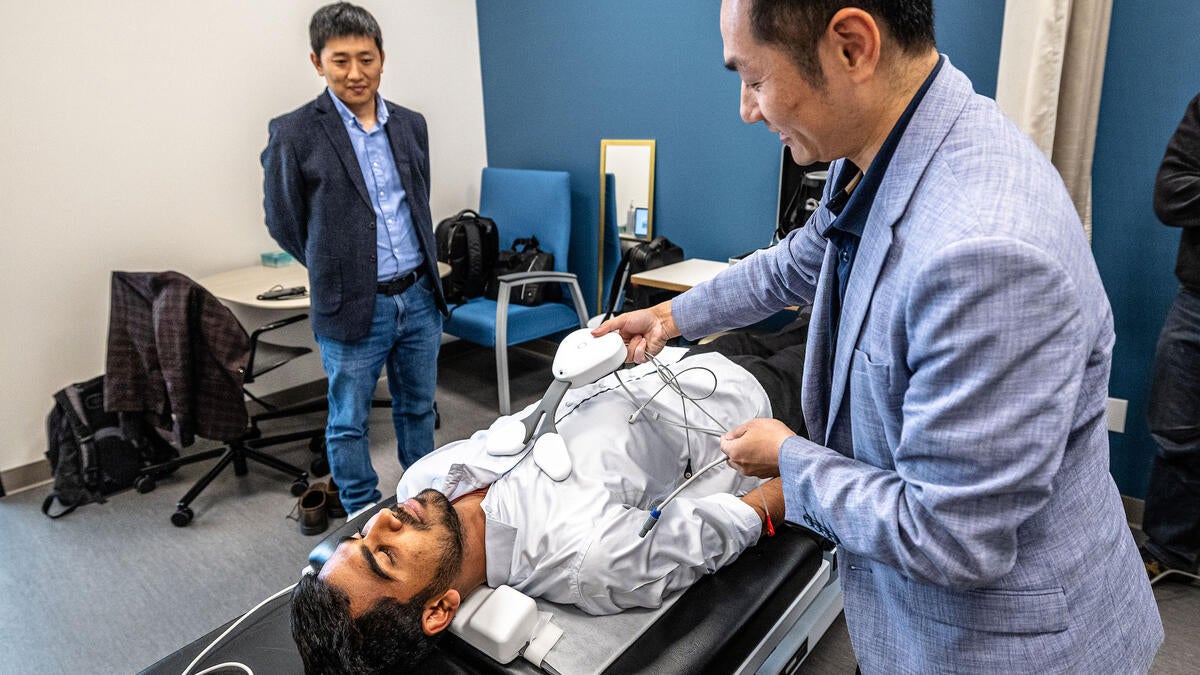 Man demonstrates new cardiac device as another man watches on.