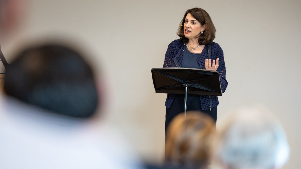 Woman speaking behind lectern at event