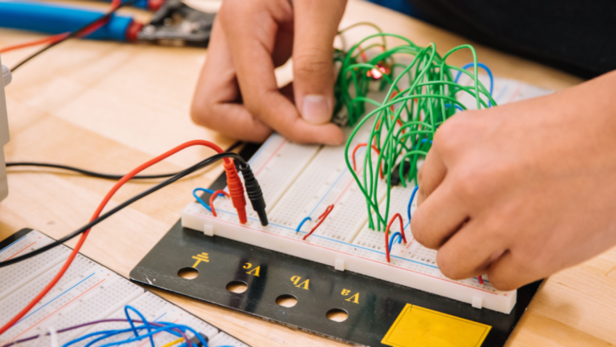 Hands putting together rudimentary circuit board