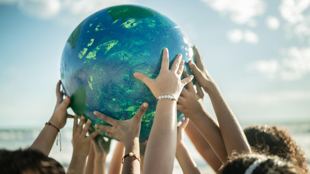 Kids hands holding up globe