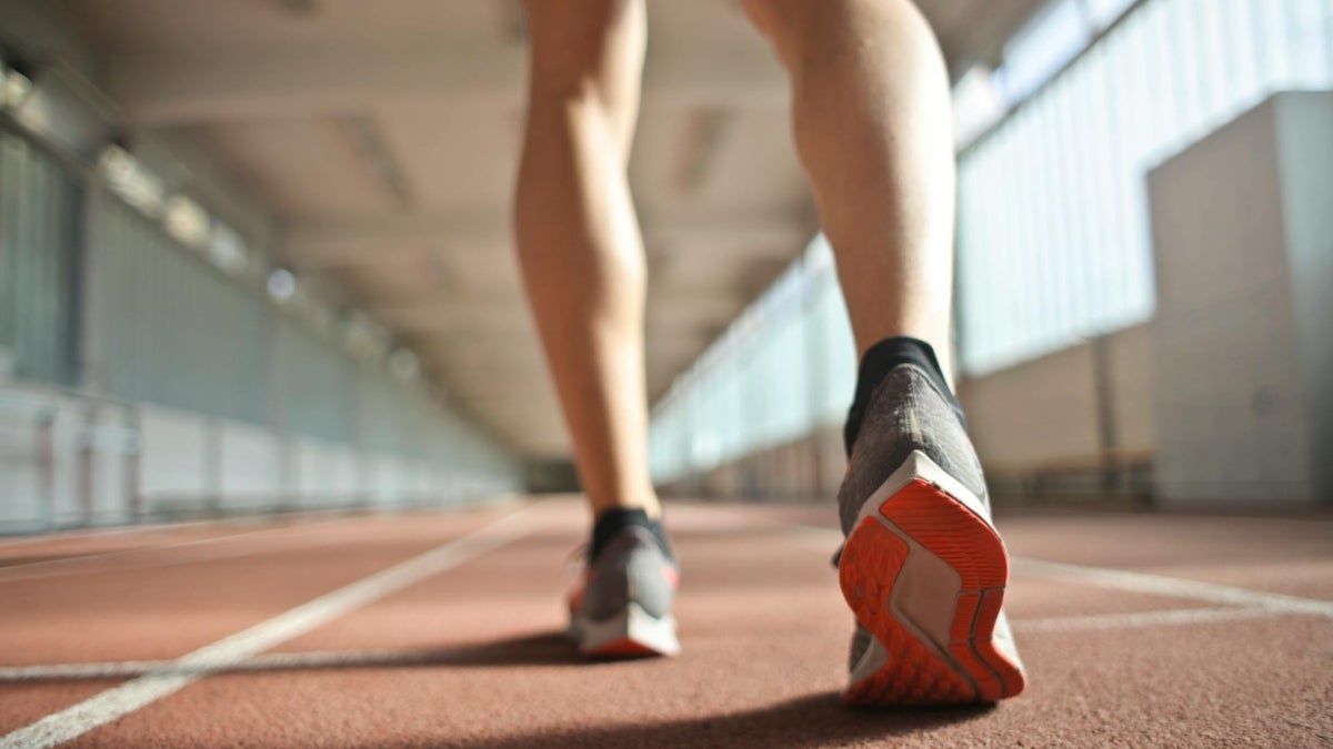 Legs of runner standing on race track