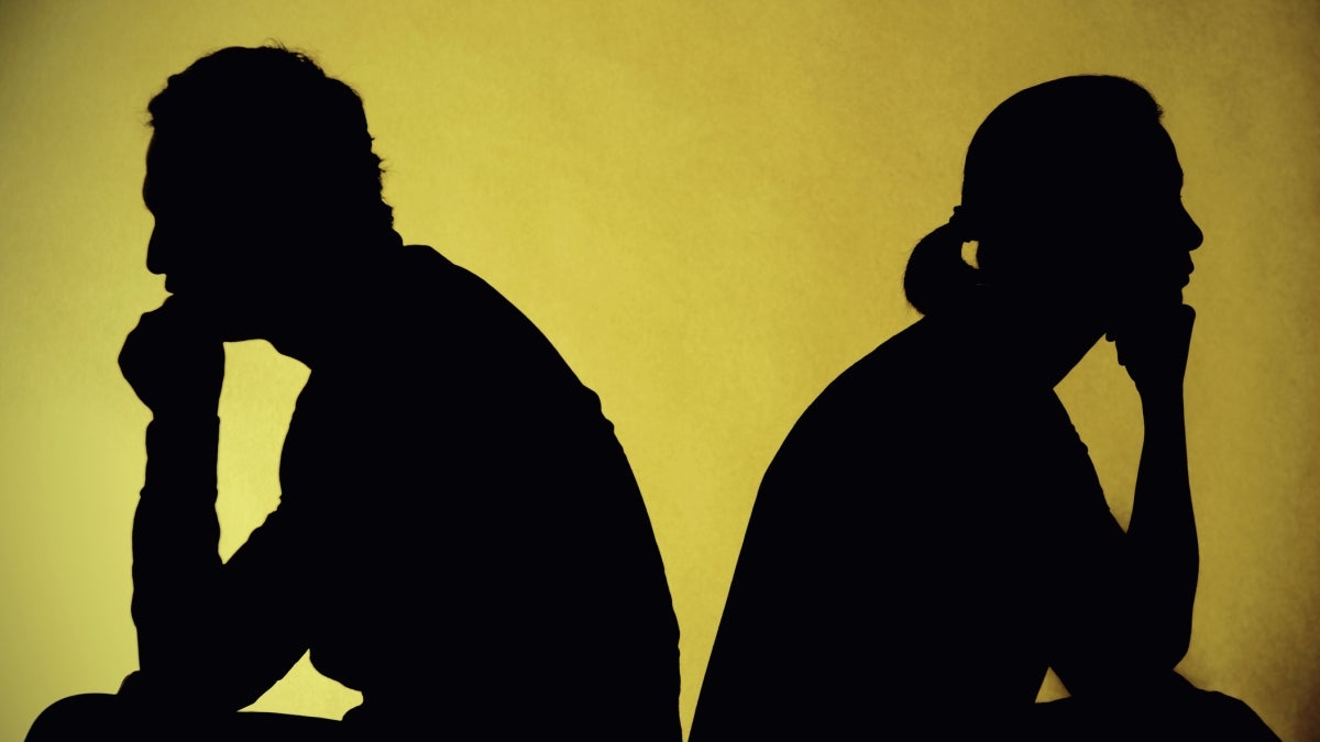 Silhouettes of two people sitting back to back