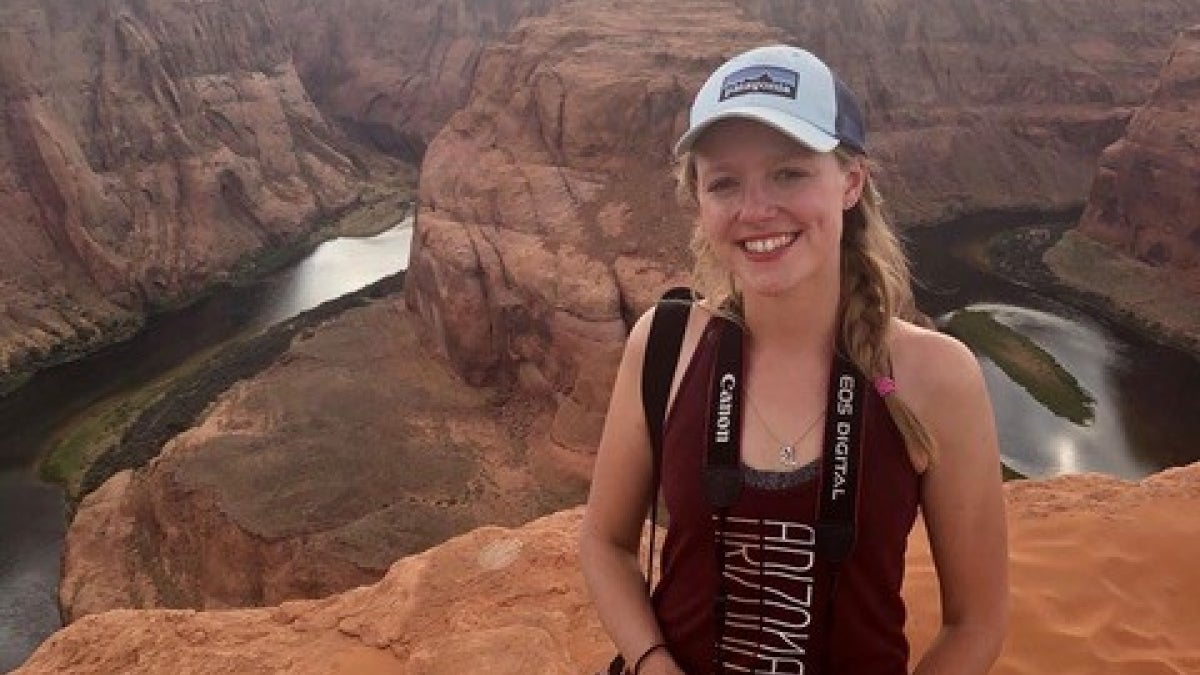 Alexandra Pye stands on the edge of a high ridge above Horseshoe Bend.