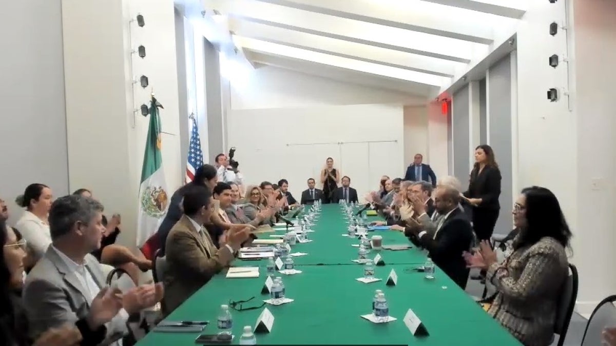 People sitting at a long table facing each other.