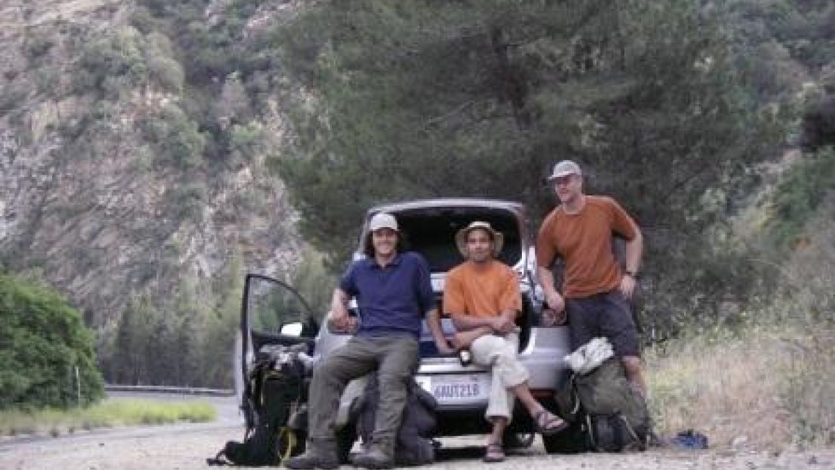 three men sitting in back of car