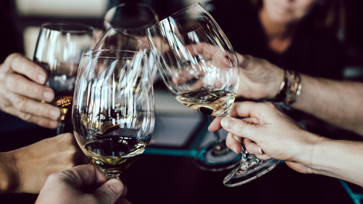 An image of people toasting with wine glasses