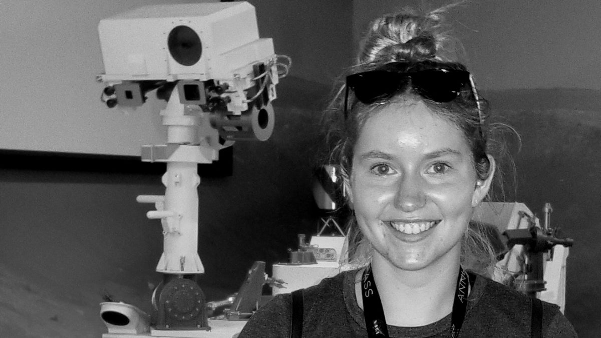 ASU graduate Emma Softich stands in front of a Mars rover.