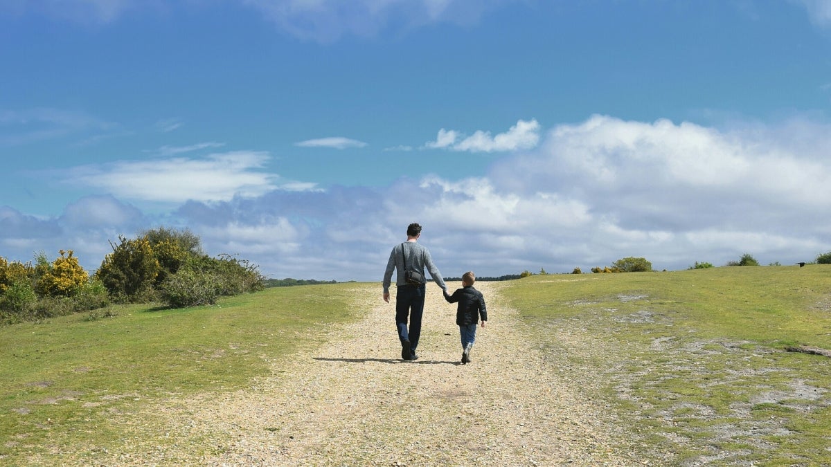 man and child walking along a path