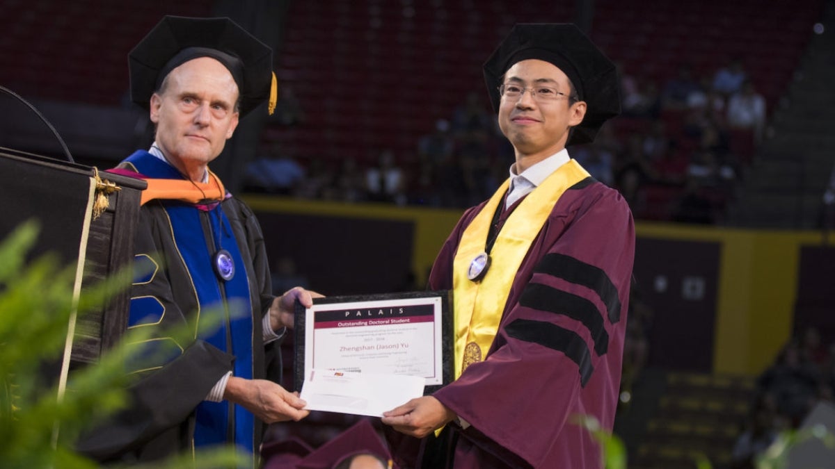 Photo of Steve Phillips and Zhengshan “Jason” Yu holding a plaque.