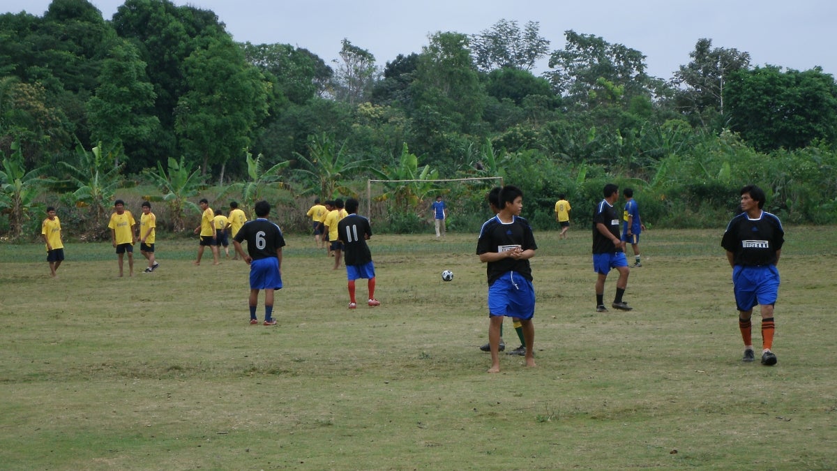 people playing soccer in a field