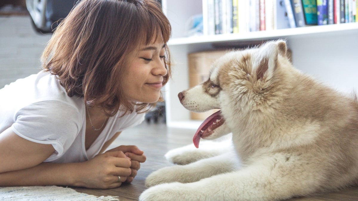 A woman smiles at her dog