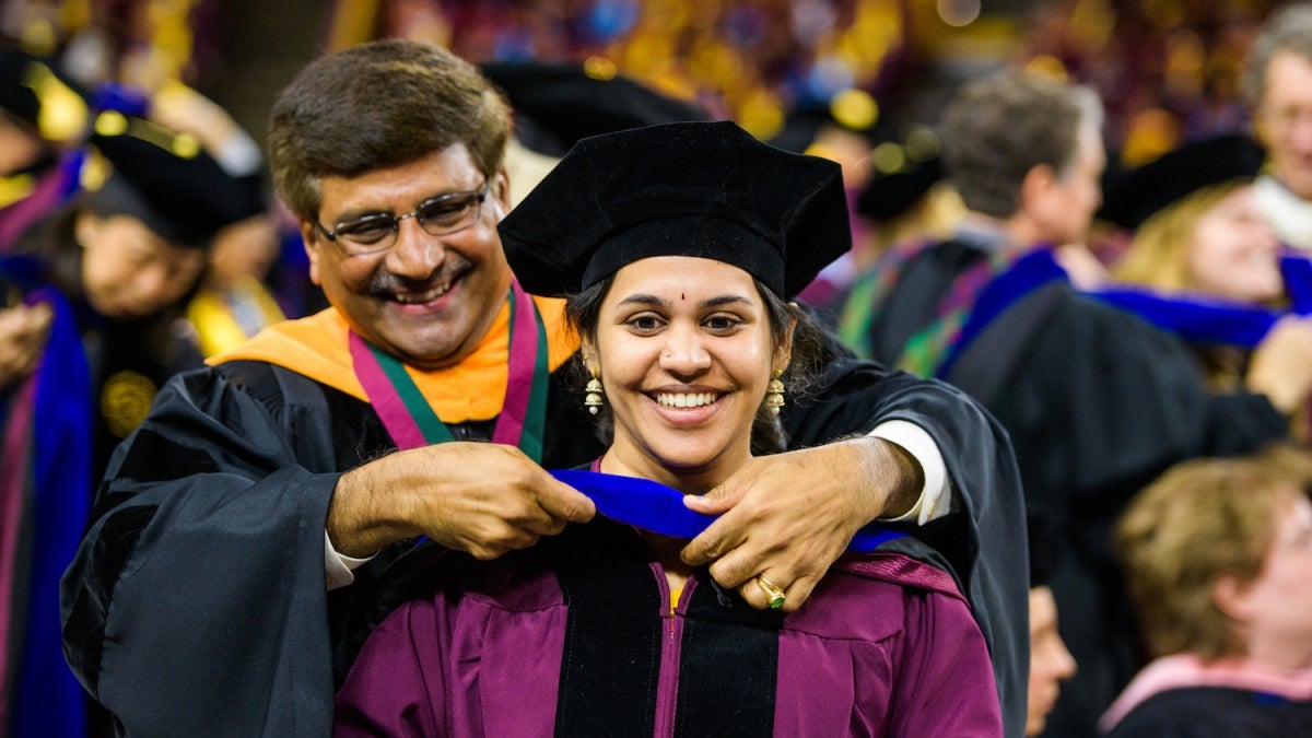 graduate and faculty member at graduation