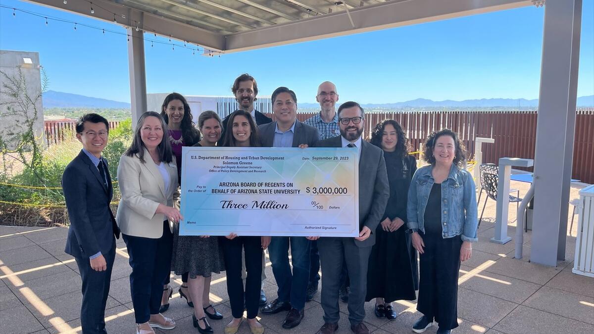 Group of people holding a large check.