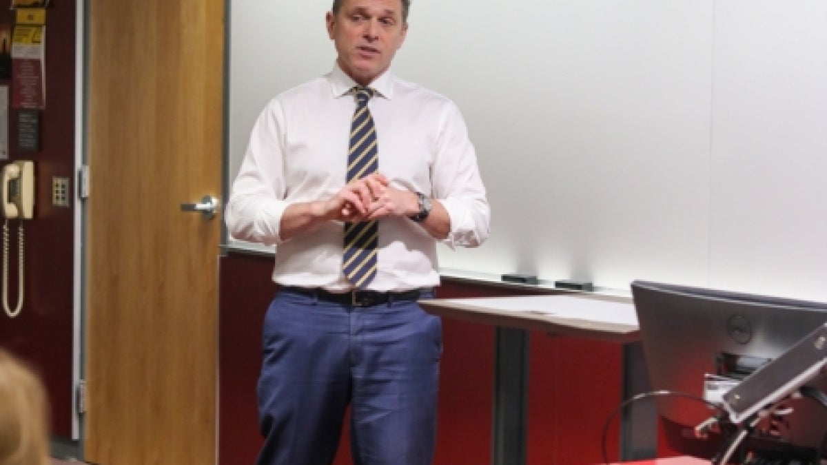 Foreign Service Officer Tom Wotka standing at the front of a classroom speaking.