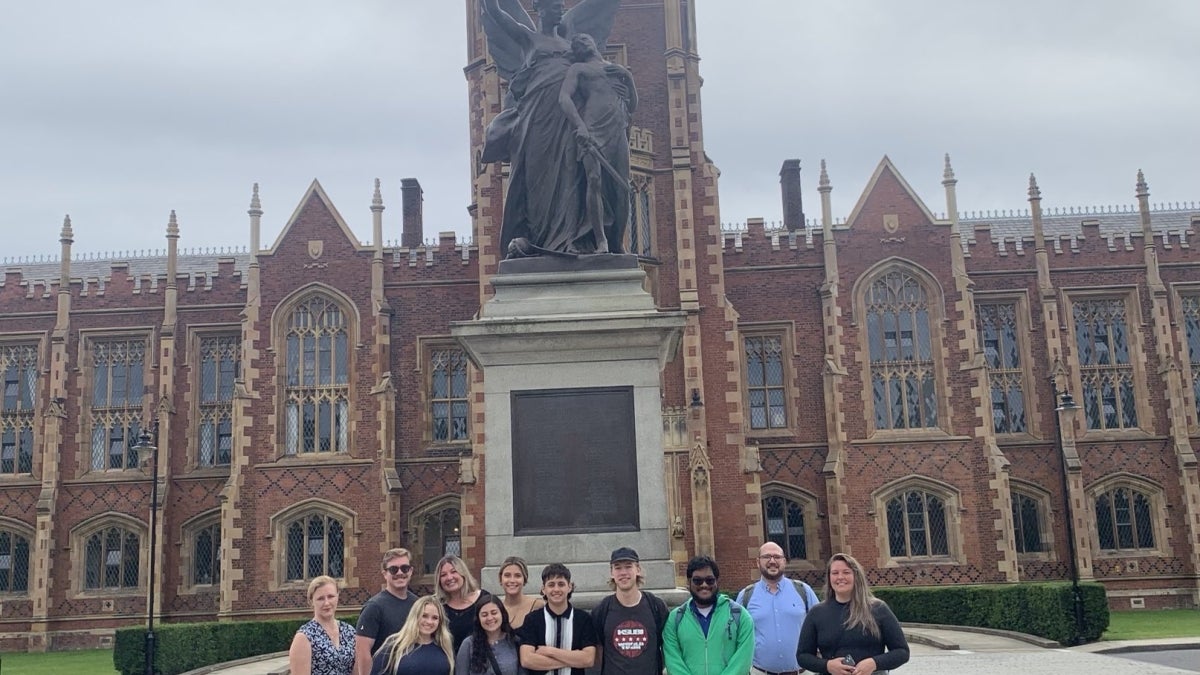 Group of people standing in front of an ornate building.