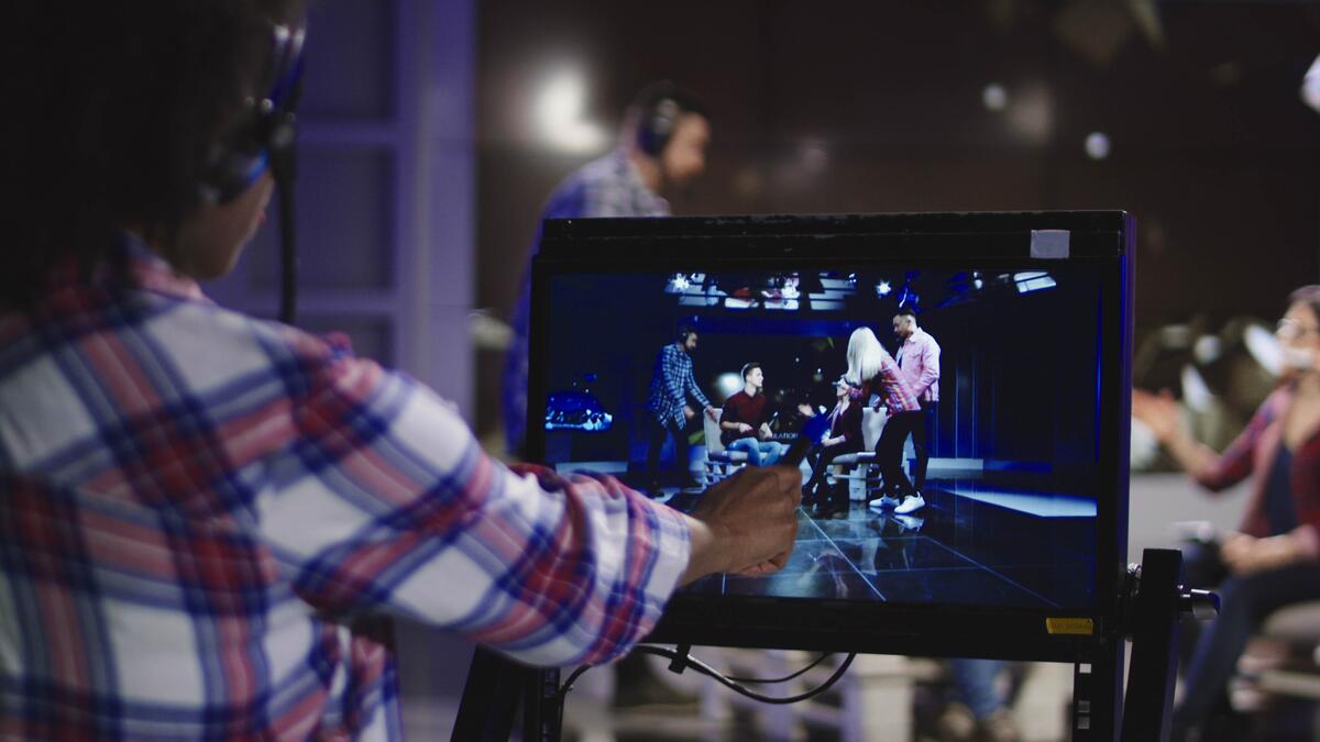 Black director looking at a monitor on a film set.