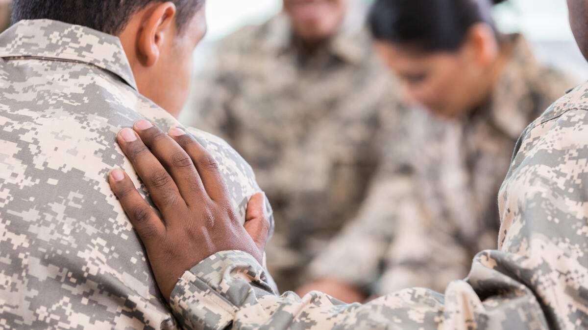 Military members comforting each other