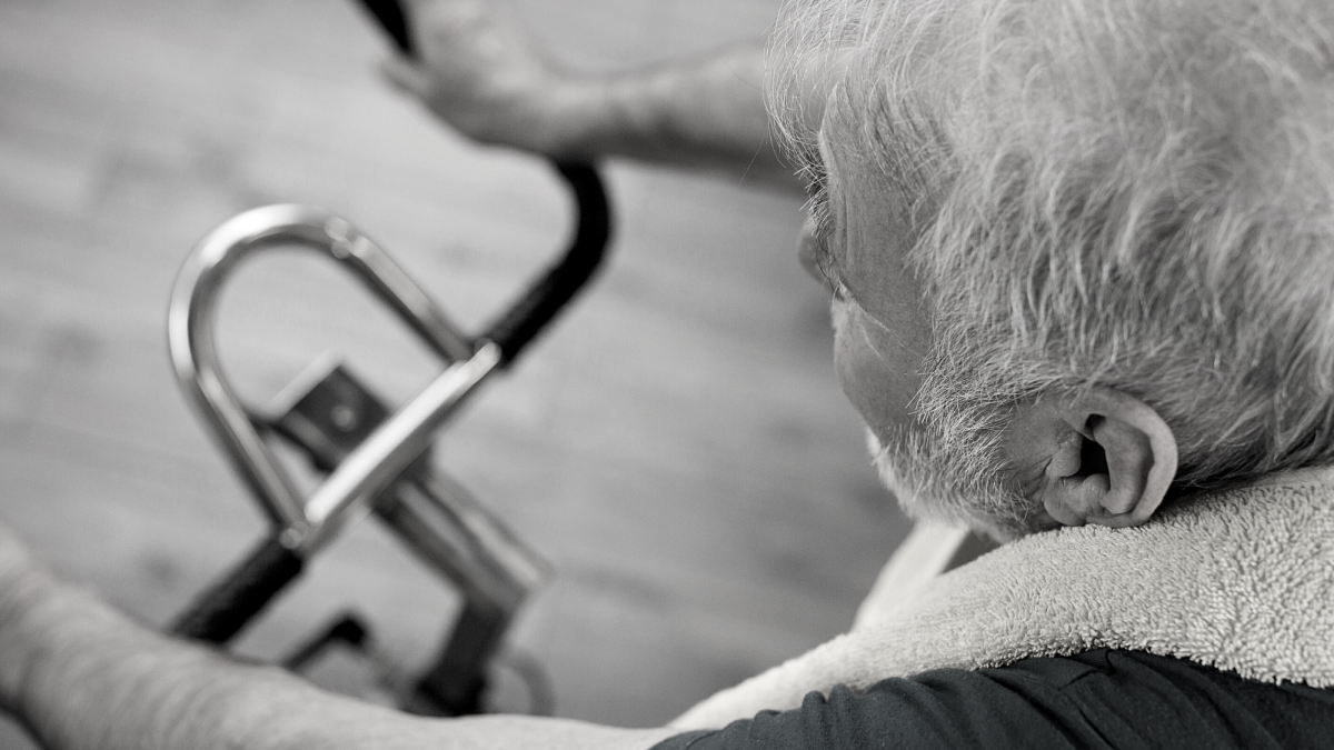 Stock image - an older man exercises on a stationary bike