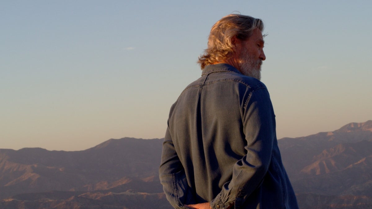 still of man with mountains behind him from documentary