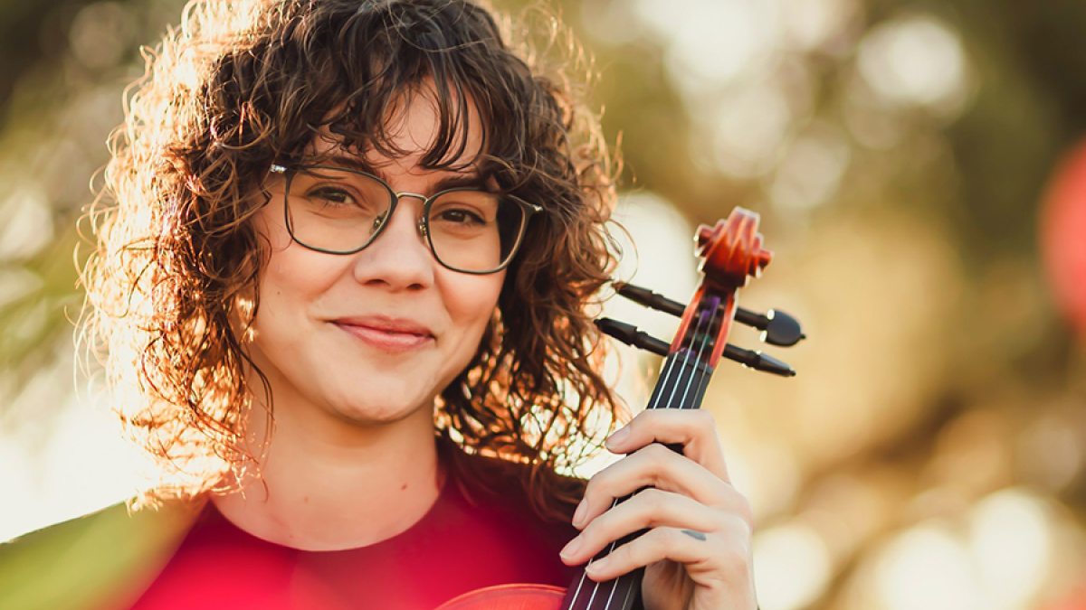 Headshot of La Tasha Butler holding a violin.