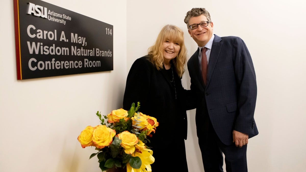 two people posing next to conference room sign