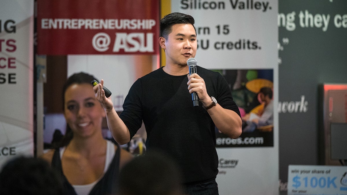 Man speaking into a microphone at an ASU entreprenership event.