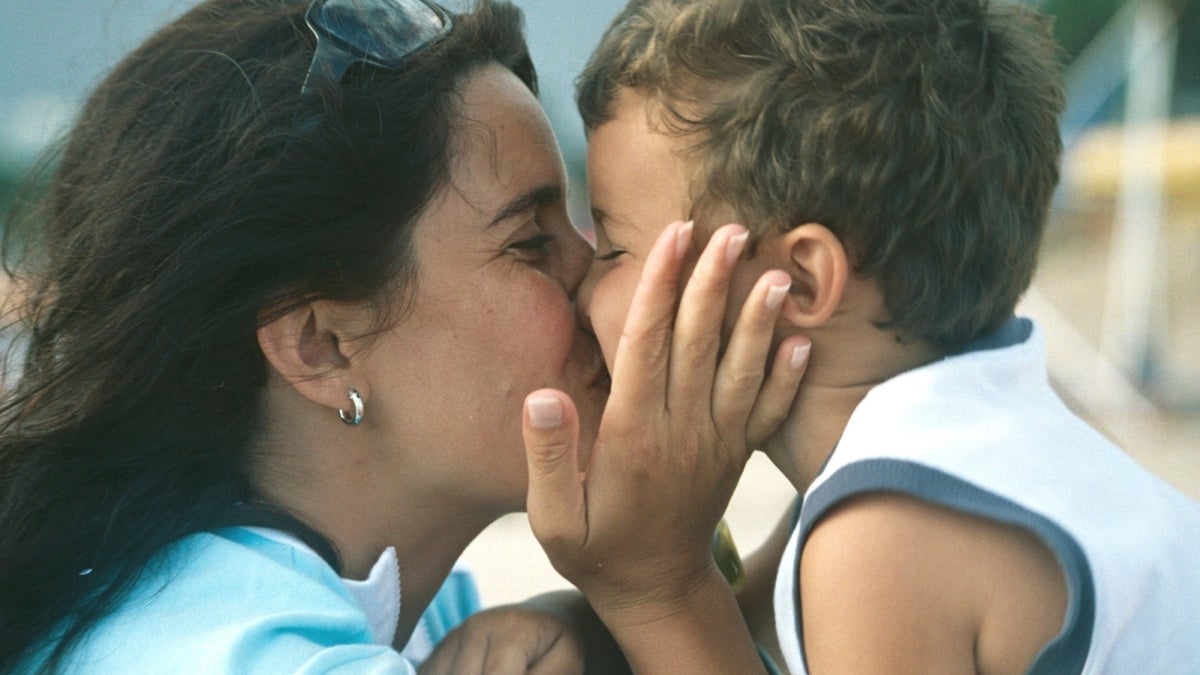 Mother kissing child