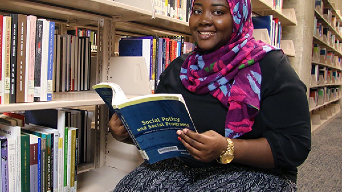 woman sitting with book in library