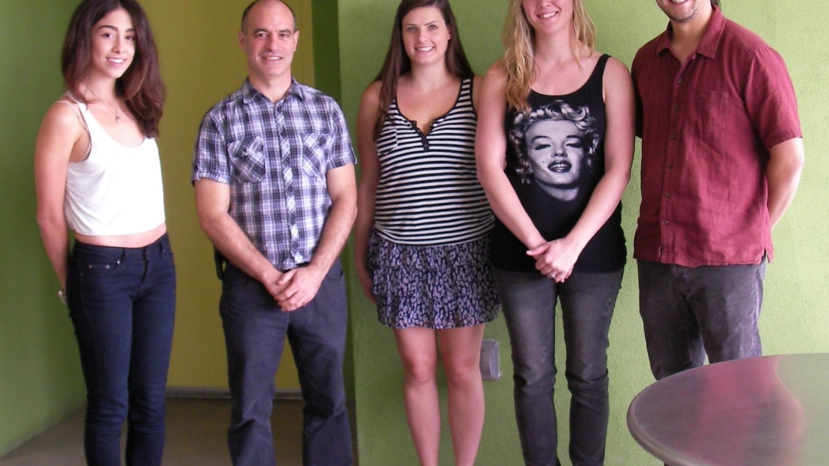 Three women and two men pose for the camera.