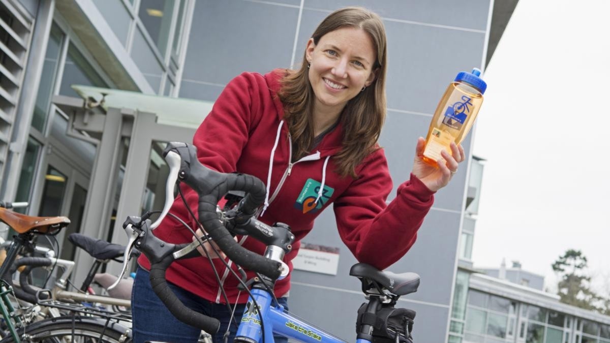 woman next to bike holding water bottle