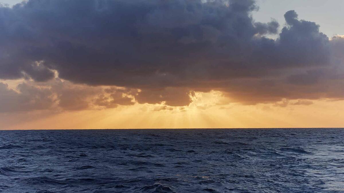 sunset with clouds over ocean waters