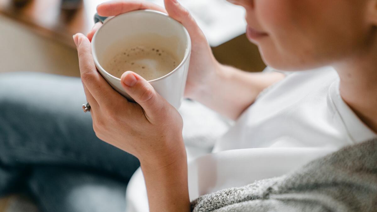 Woman holding cup of coffee, smiling