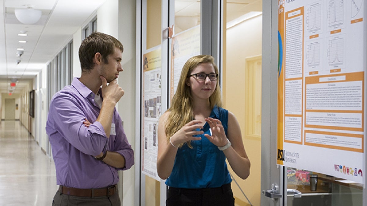 Cailin Treseder, a University of New Mexico student with a Research Experiences for Undergraduates pilot program, presents her research to assistant professor Zachary Holman in the summer of 2013.