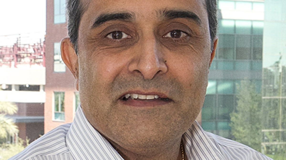 male Indian American Rajesh Buch in white collared shirt and black hair