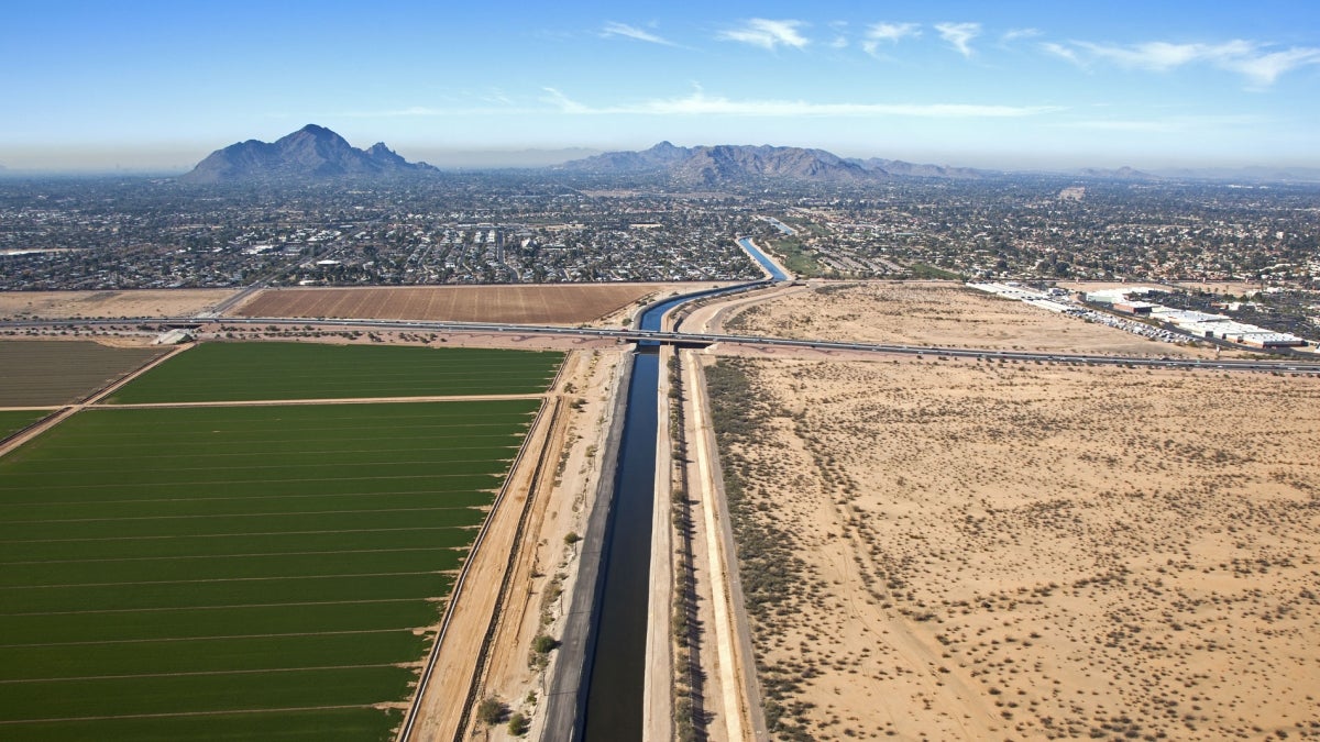 A canal near agricultural fields and infrastructure in the Phoenix metropolitan area 