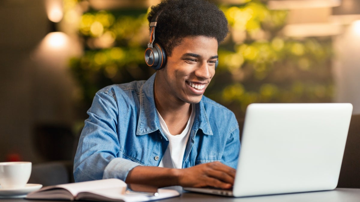 teen gamer playing video games on laptop