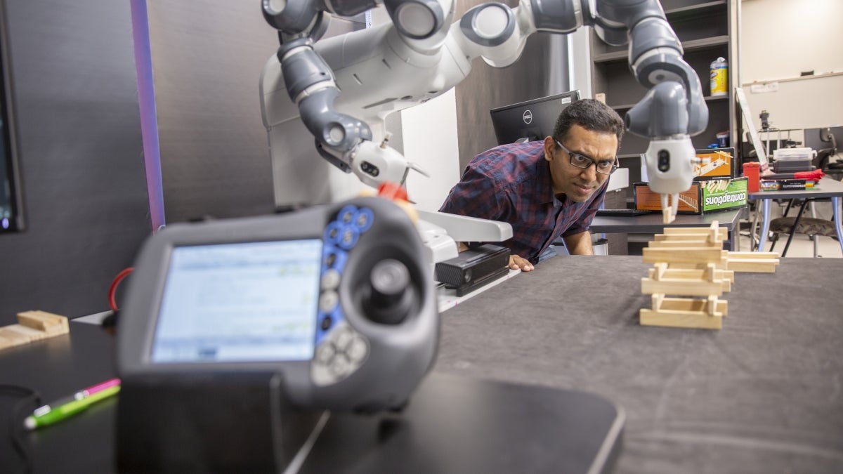 man working with a robot in a lab