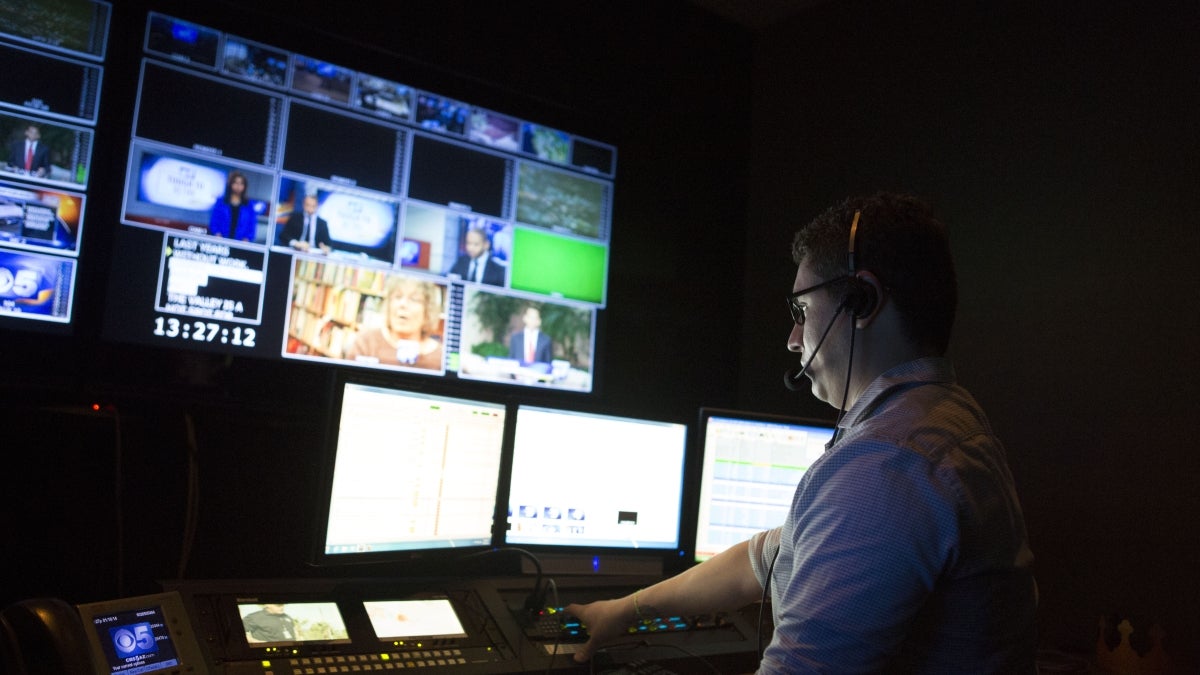 man in broadcast news control room