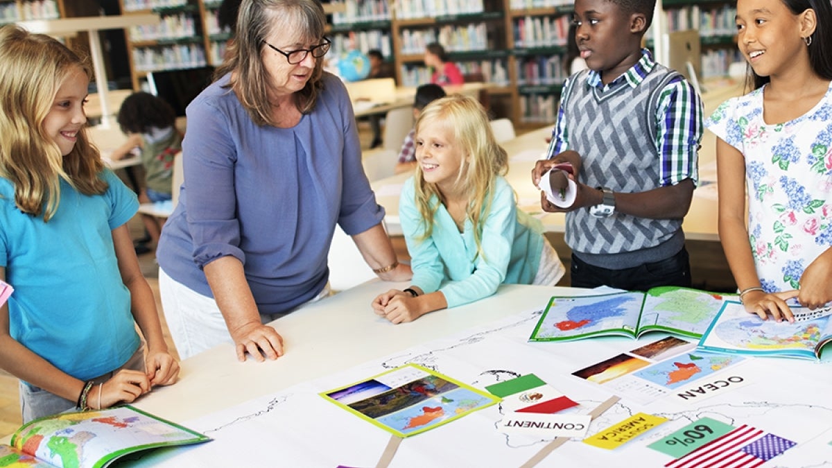 Teacher and students interacting in a classroom.