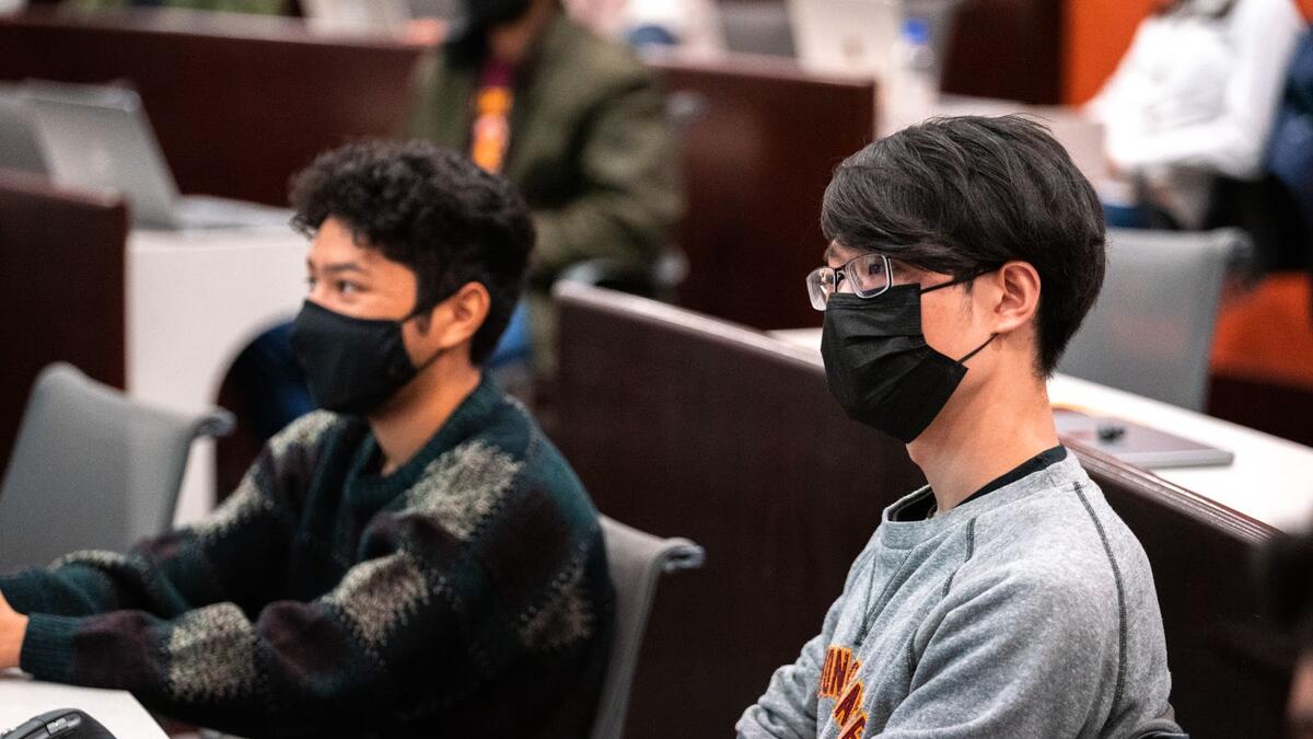 Students in a classroom listening and looking toward a speaker.